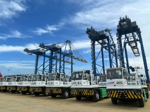 Electric tractors and quay cranes beside the berth of CWIT.