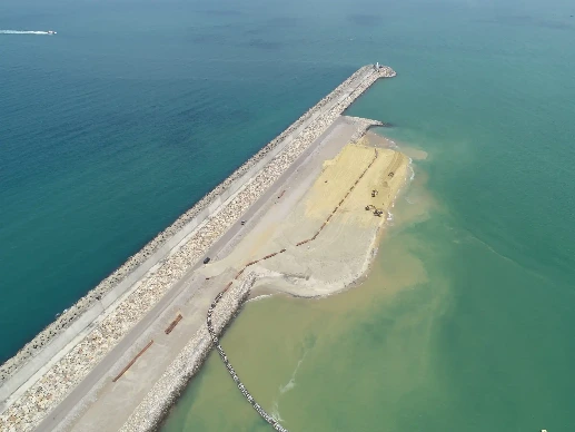 Aerial view of a port with breakwater and harbor.