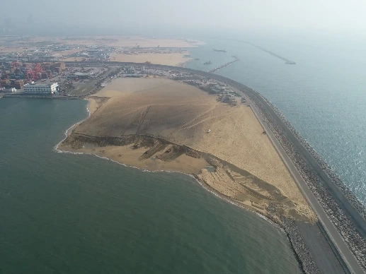 Breakwater of CWIT curving into harbor with the city behind