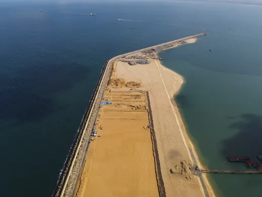 An aerial view a hook-shaped breakwater under construction at CWIT.