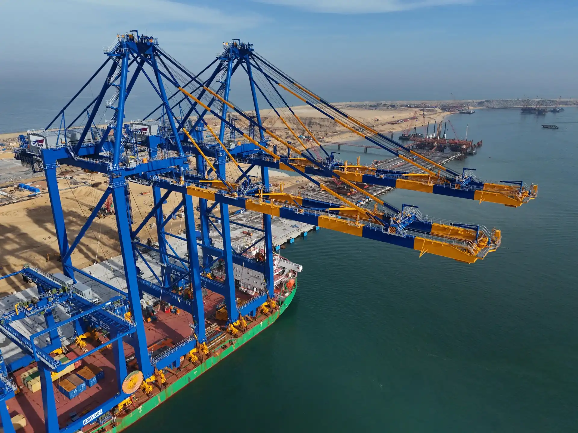 A crane ship with yellow and blue cranes docked at CWIT's berth.