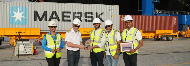 A crane ship with yellow and blue cranes docked at CWIT's berth.
